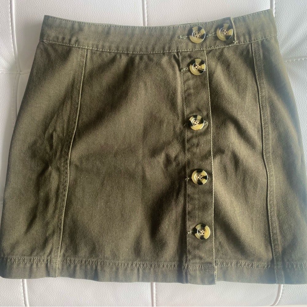 Green denim mini skirt with tortoise buttons